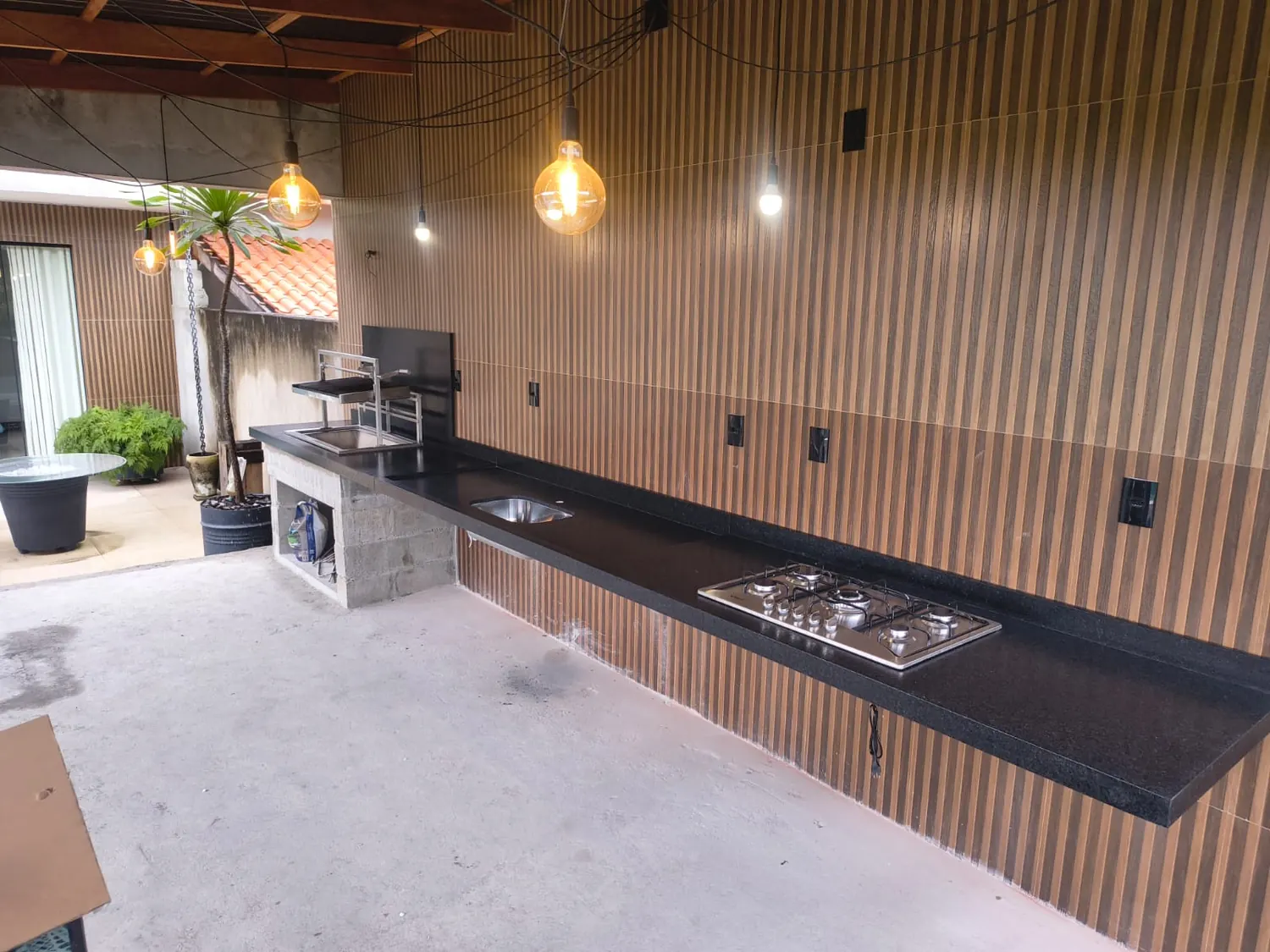 Área gourmet com bancada em pedra escura