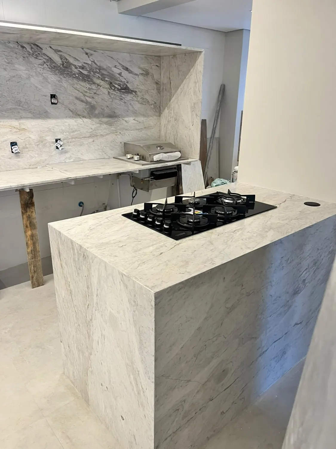 Ilha com cooktop em pedra clara